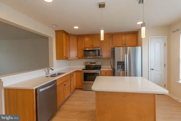 a kitchen with a sink a stove a refrigerator and white cabinets