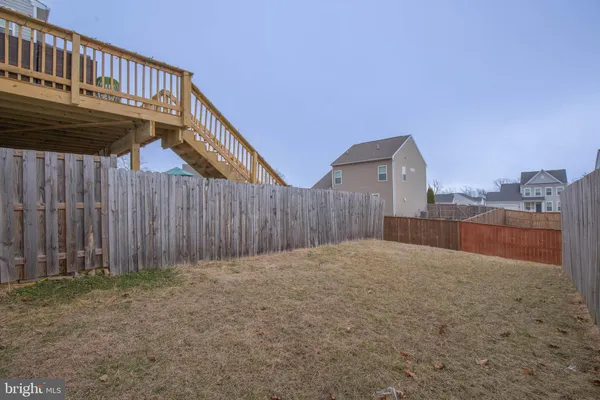 a view of an house with backyard and wooden fence