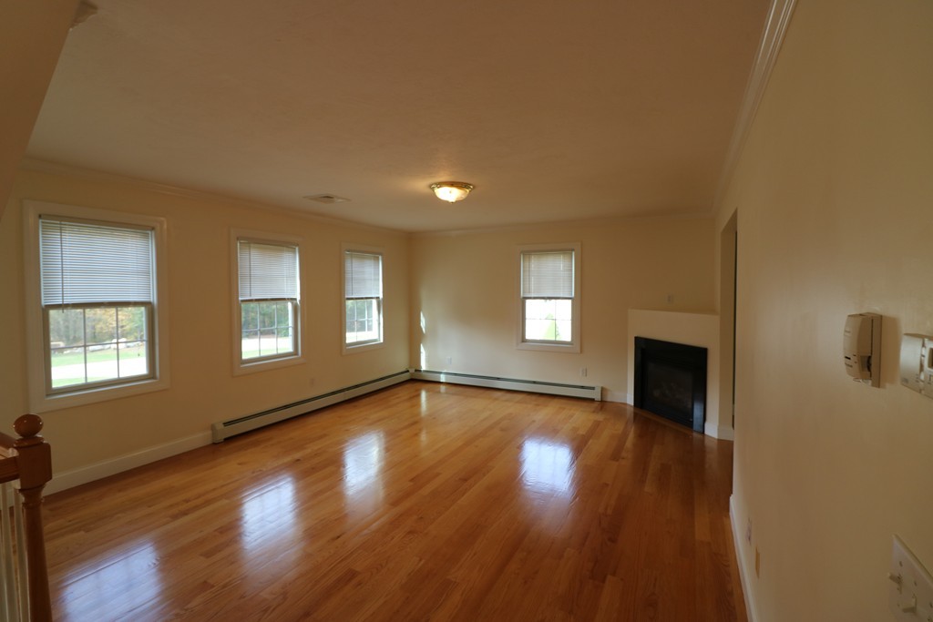 68 Brookfield Road, Unit 202 Charlton, MA 01507 - Photo 2 of 13 a view of an empty room with a window and wooden floor