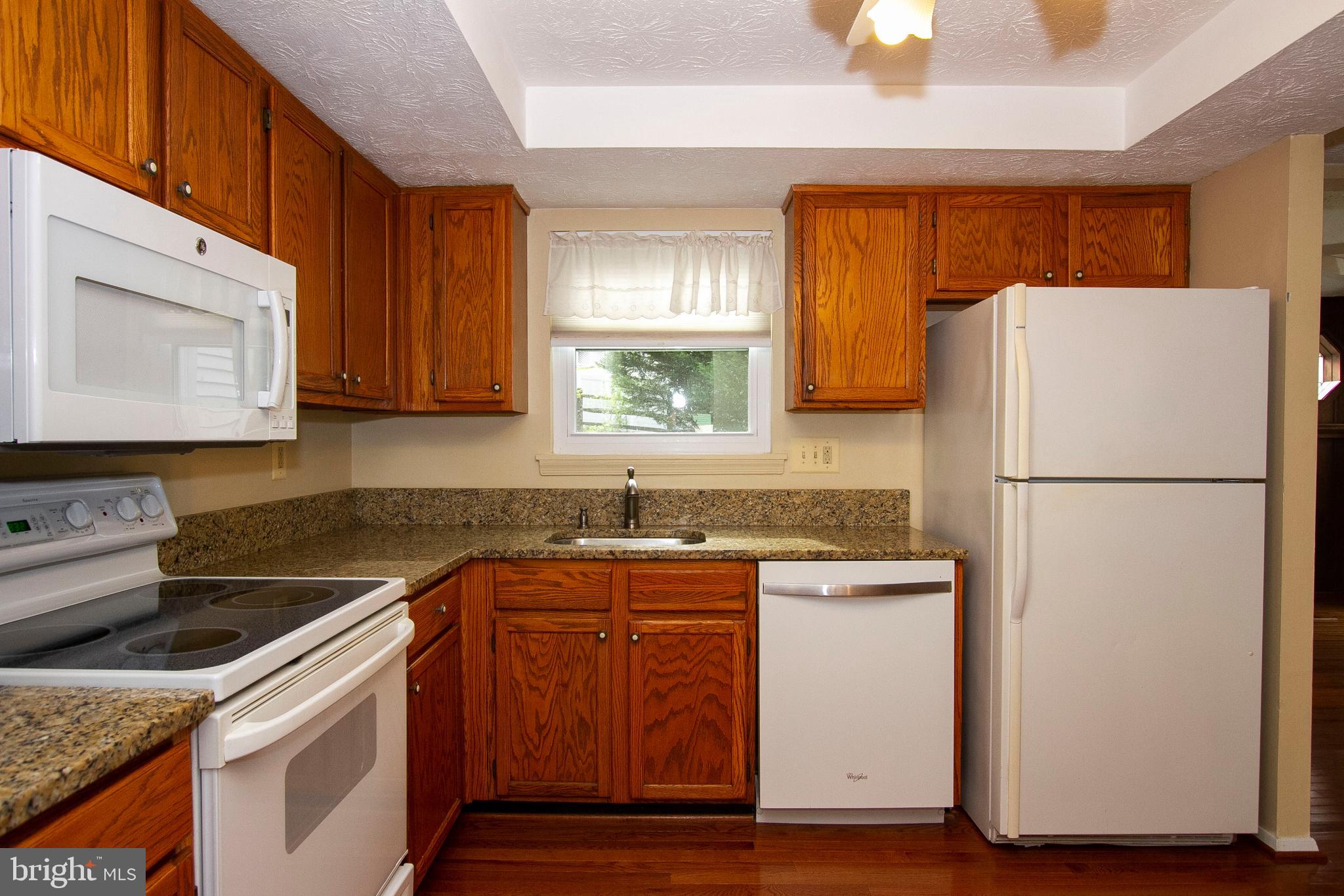 9403 Perglen Road Nottingham, MD 21236 - Photo 14 of 34 a kitchen with a sink a refrigerator and cabinets