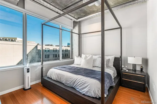 a bedroom with a bed and a large window