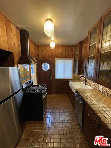a kitchen with granite countertop a stove top oven and cabinets