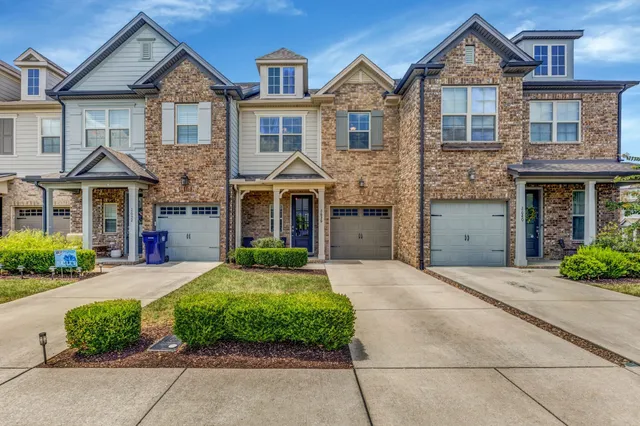a front view of a house with a yard and potted plants