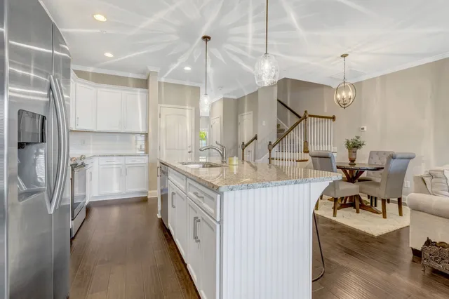 a kitchen with stainless steel appliances granite countertop a kitchen island hardwood floor and a sink