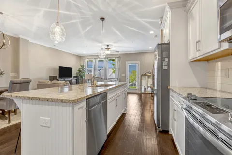 a kitchen with granite countertop a sink a counter space appliances and cabinets