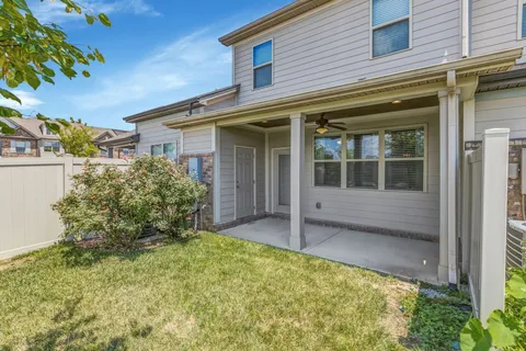 a view of house with backyard and glass windows