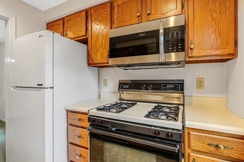 67 Providence Road, Unit 1 Grafton, MA 01519 - Photo 3 of 23 a kitchen with stainless steel appliances a stove a microwave and cabinets
