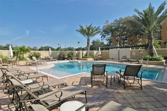a view of a patio with table and chairs potted plants and palm tree