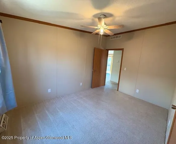 a view of an empty room with a chandelier fan