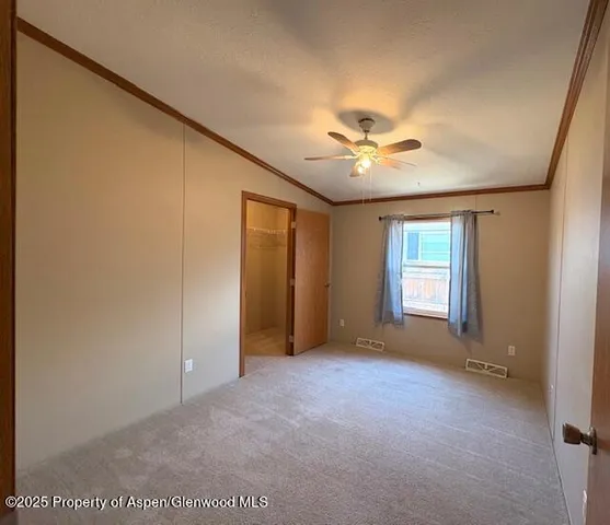 an empty room with windows and a ceiling fan