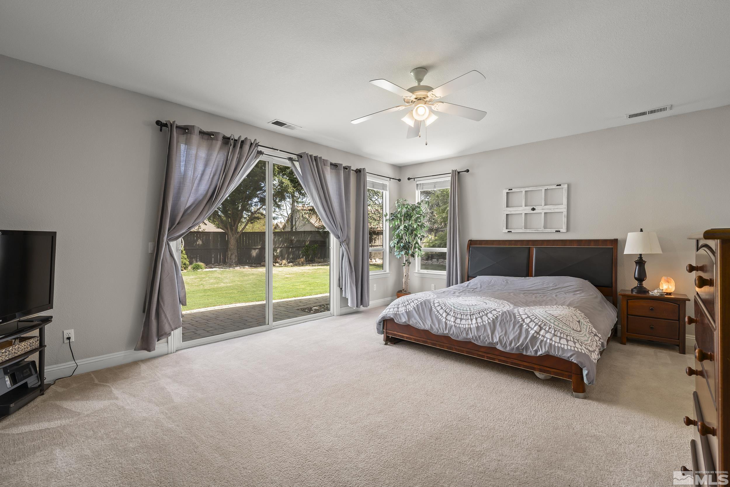 641 Aberdeen Court Reno, NV 89521 - Photo 14 of 39 a spacious bedroom with a bed and a flat tv screen