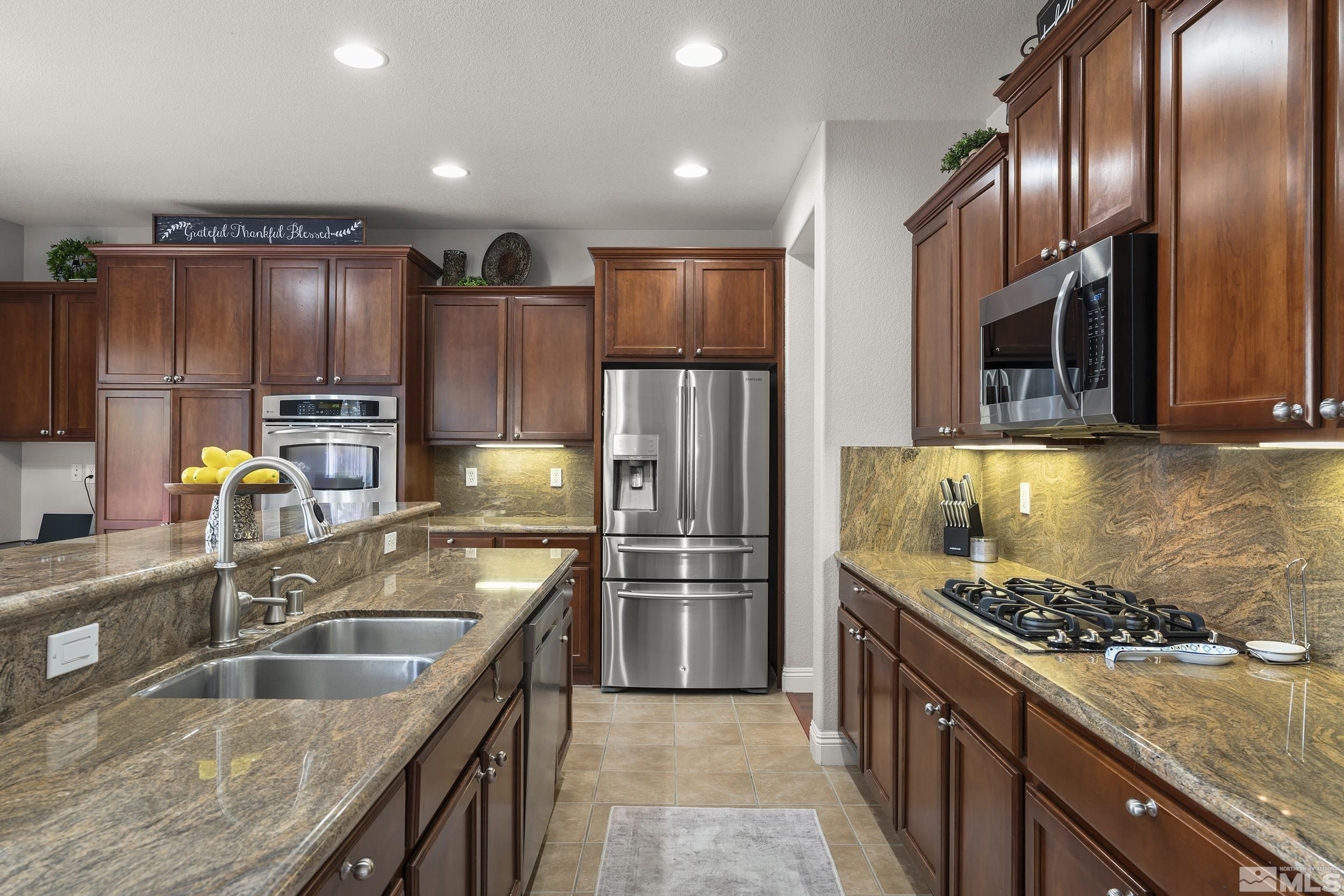 641 Aberdeen Court Reno, NV 89521 - Photo 8 of 39 a kitchen with granite countertop a sink stainless steel appliances and cabinets