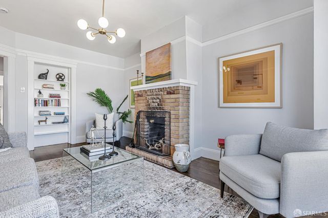 a living room with furniture a chandelier and a fireplace