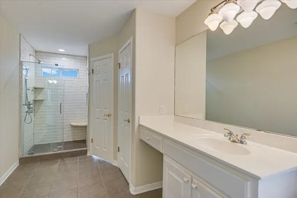 a bathroom with a double vanity sink mirror and shower
