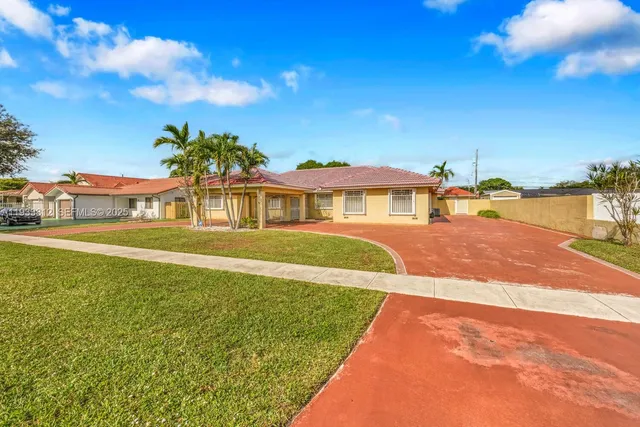 a front view of a house with a garden and yard