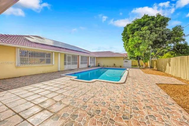a view of a patio with table and chairs with wooden floor and fence