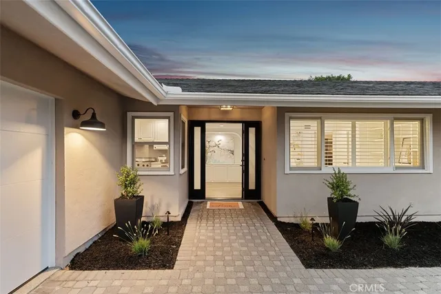 a front view of a house with a potted plant