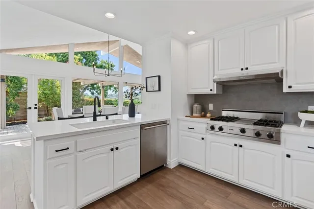 a kitchen with kitchen island a refrigerator stove and white cabinets