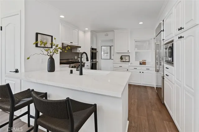 a kitchen with granite countertop white cabinets and appliances