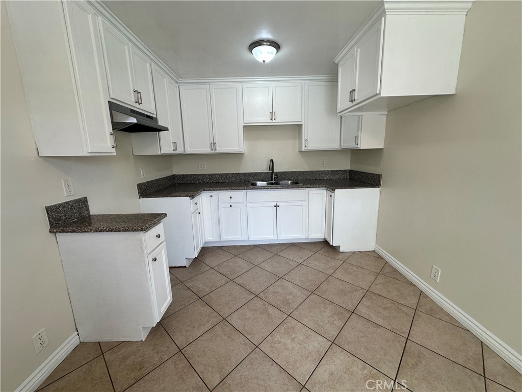 10516 Clovis Avenue Los Angeles, CA 90002 - Photo 3 of 13 a kitchen with granite countertop white cabinets sink and stainless steel appliances