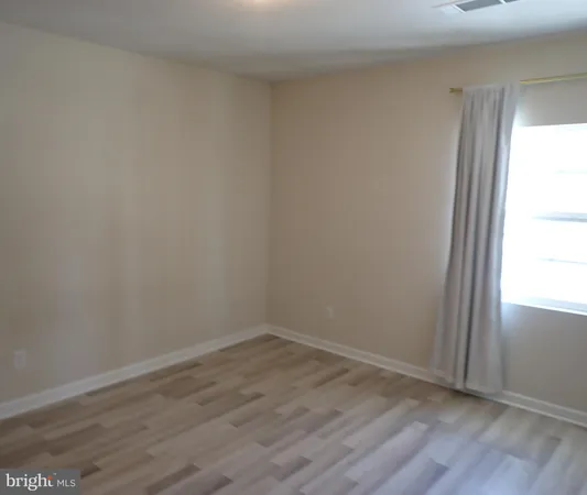 a view of a small space with wooden floor and a window