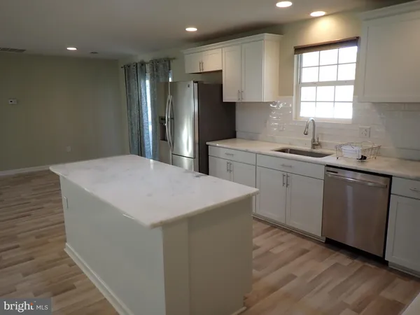 a kitchen with a sink a refrigerator and window