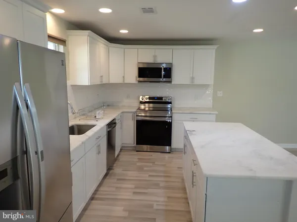 a kitchen with stainless steel appliances a refrigerator sink and microwave