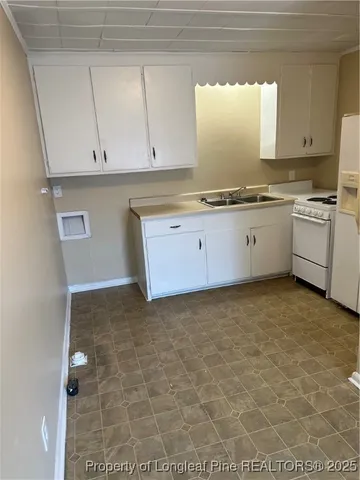 a kitchen with granite countertop white cabinets and white appliances