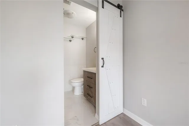 a bathroom with a granite countertop toilet and a shower