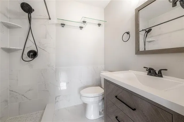 a bathroom with a sink a toilet and a shower