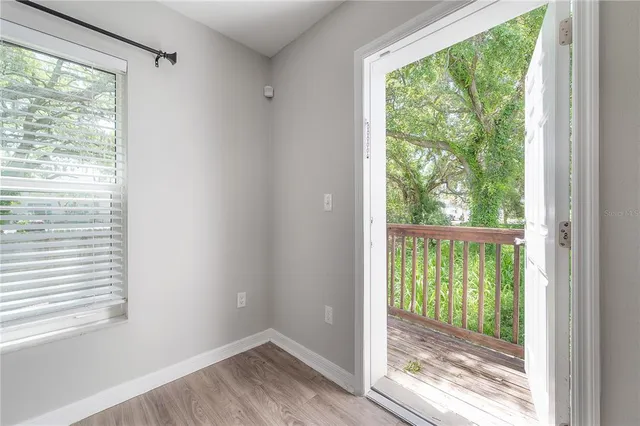 a view of empty room with wooden floor and doors