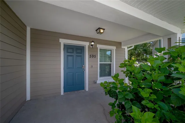 front view of a house with a yard and potted plants