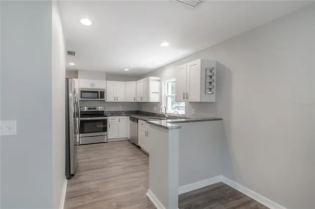 a kitchen with stainless steel appliances granite countertop a refrigerator and a sink