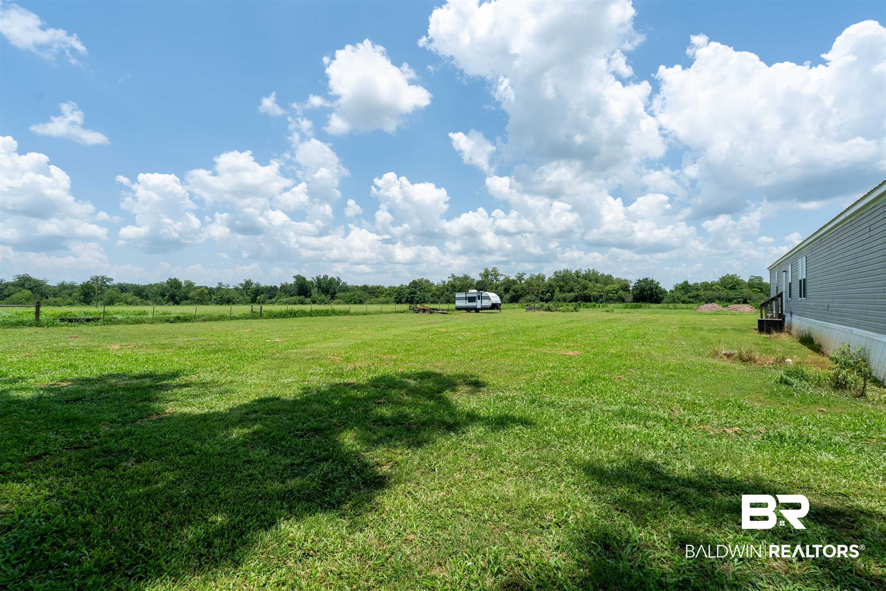 15575 Mikkelsen Road Summerdale, AL 36580 - Photo 36 of 68 Expansive green lawn providing ample open space, bordered by mature trees in the distance