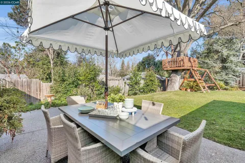 a view of a patio with a table and chairs under an umbrella