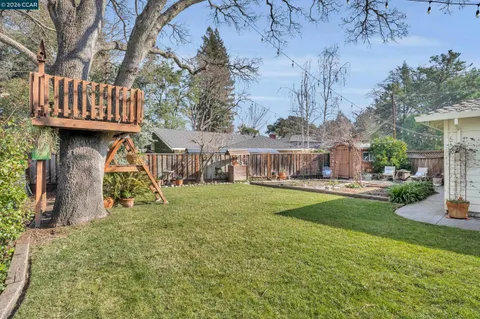 a view of a house with backyard and sitting area