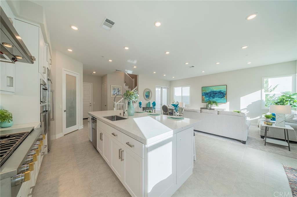 219 Chorus Irvine, CA 92618 - Photo 24 of 24 a large white kitchen with a large counter top furniture a sink and stainless steel appliances
