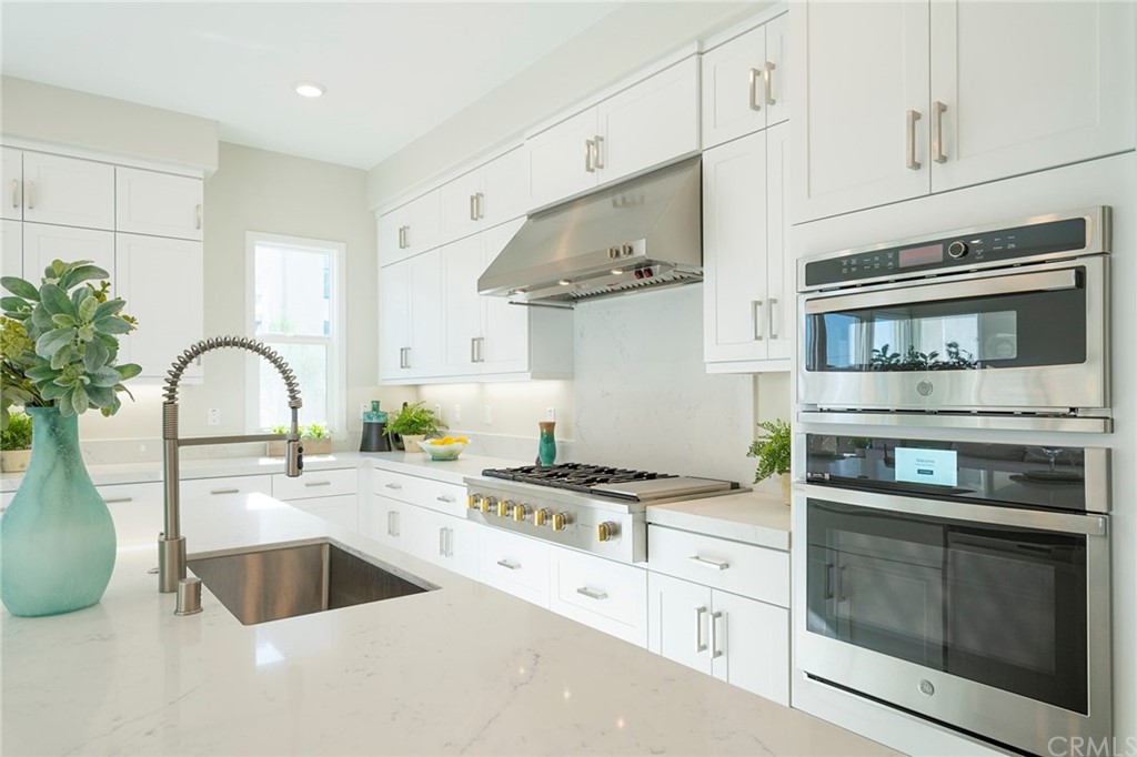 219 Chorus Irvine, CA 92618 - Photo 5 of 24 a kitchen with stainless steel appliances granite countertop a sink stove and cabinets