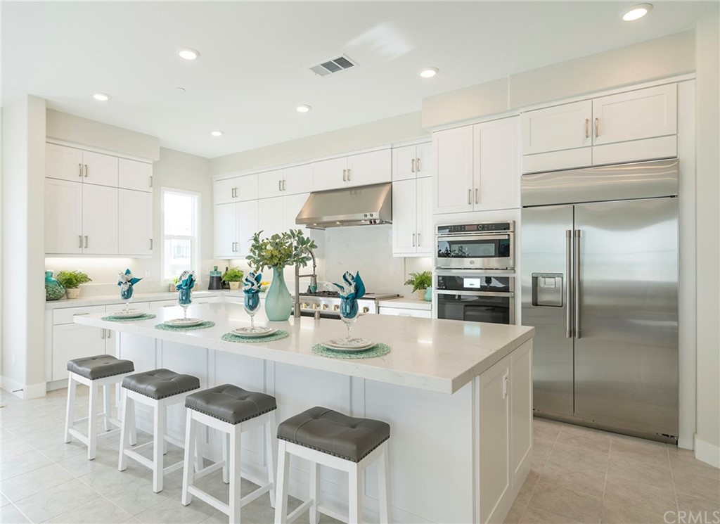 219 Chorus Irvine, CA 92618 - Photo 8 of 24 a kitchen with stainless steel appliances kitchen island granite countertop a refrigerator and a stove top oven