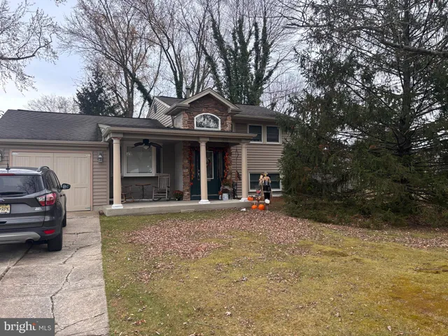 a view of a house with a yard and large tree