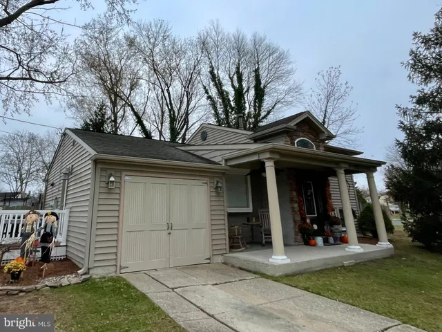 a view of a house with a large tree and wooden fence
