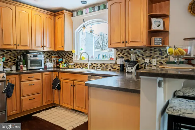 a kitchen with stainless steel appliances granite countertop a sink a stove and a microwave oven
