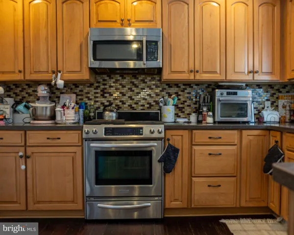 a kitchen with stainless steel appliances granite countertop a stove and a microwave