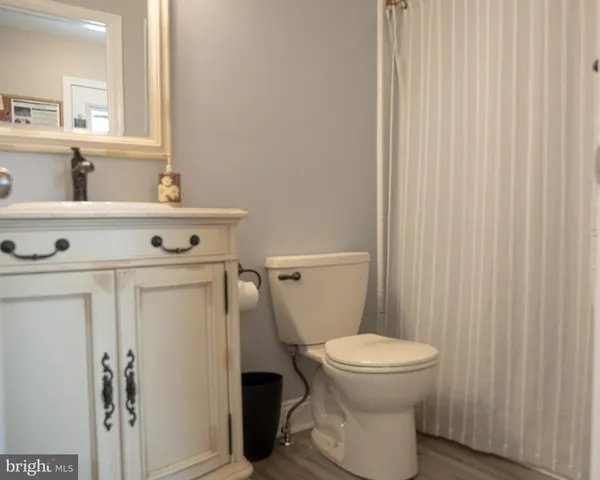 a bathroom with a toilet a sink and a mirror