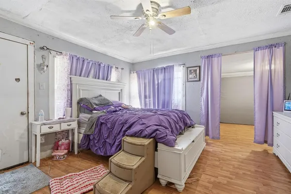a spacious bedroom with a bed and a chandelier