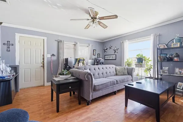 a living room with furniture and a wooden floor