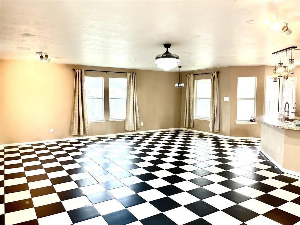 19111 Canaras Court Katy, TX 77449 - Photo 7 of 19 a view of a room with a black and white checkered floor with a gaming machine and dining chair
