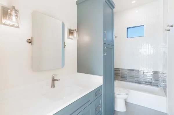a bathroom with a granite countertop sink toilet and shower