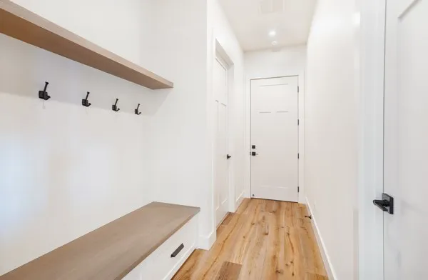a view of a hallway with wooden floor and closet