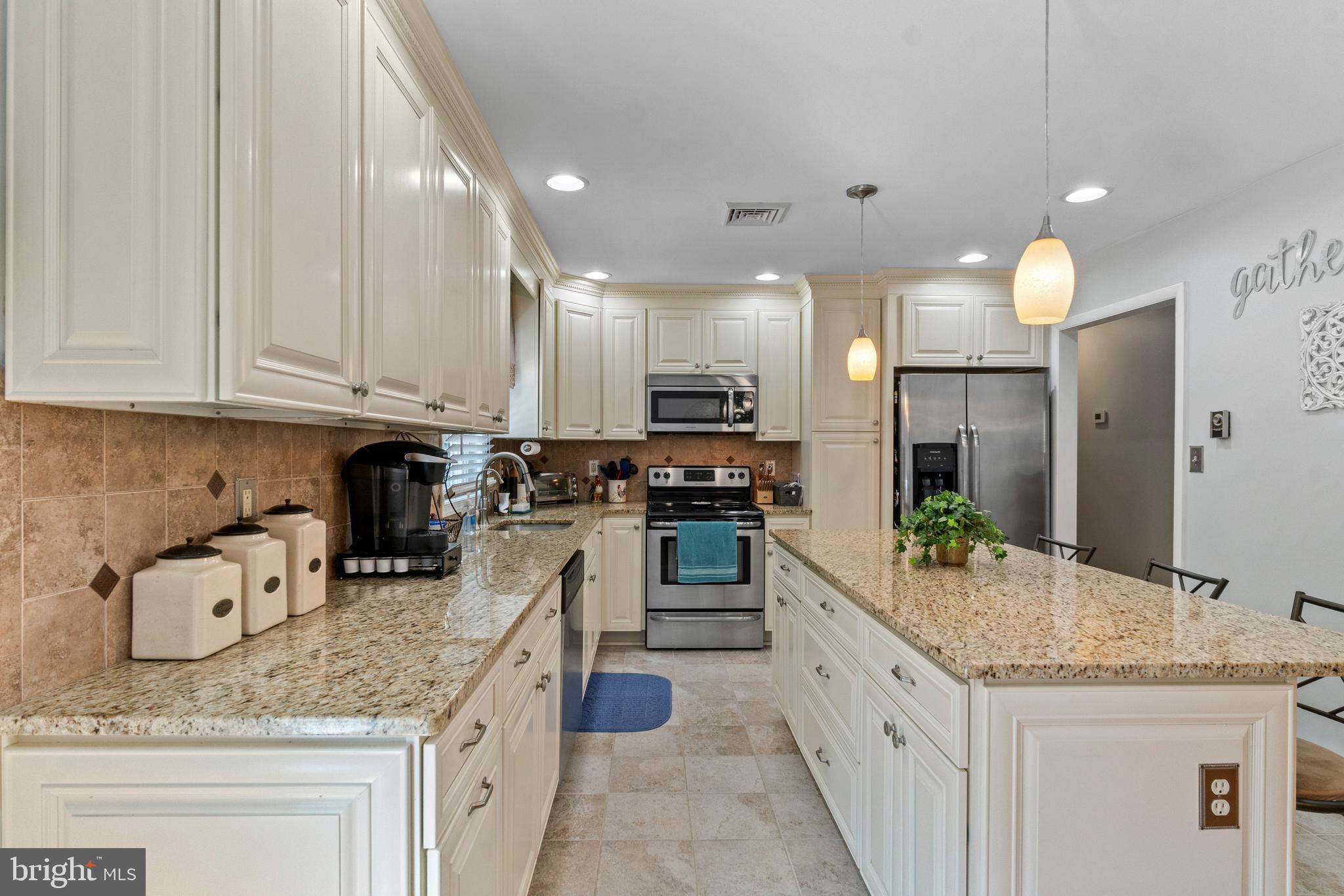 1706 Abelia Road Fallston, MD 21047 - Photo 14 of 41 a kitchen with granite countertop kitchen island white cabinets and stainless steel appliances
